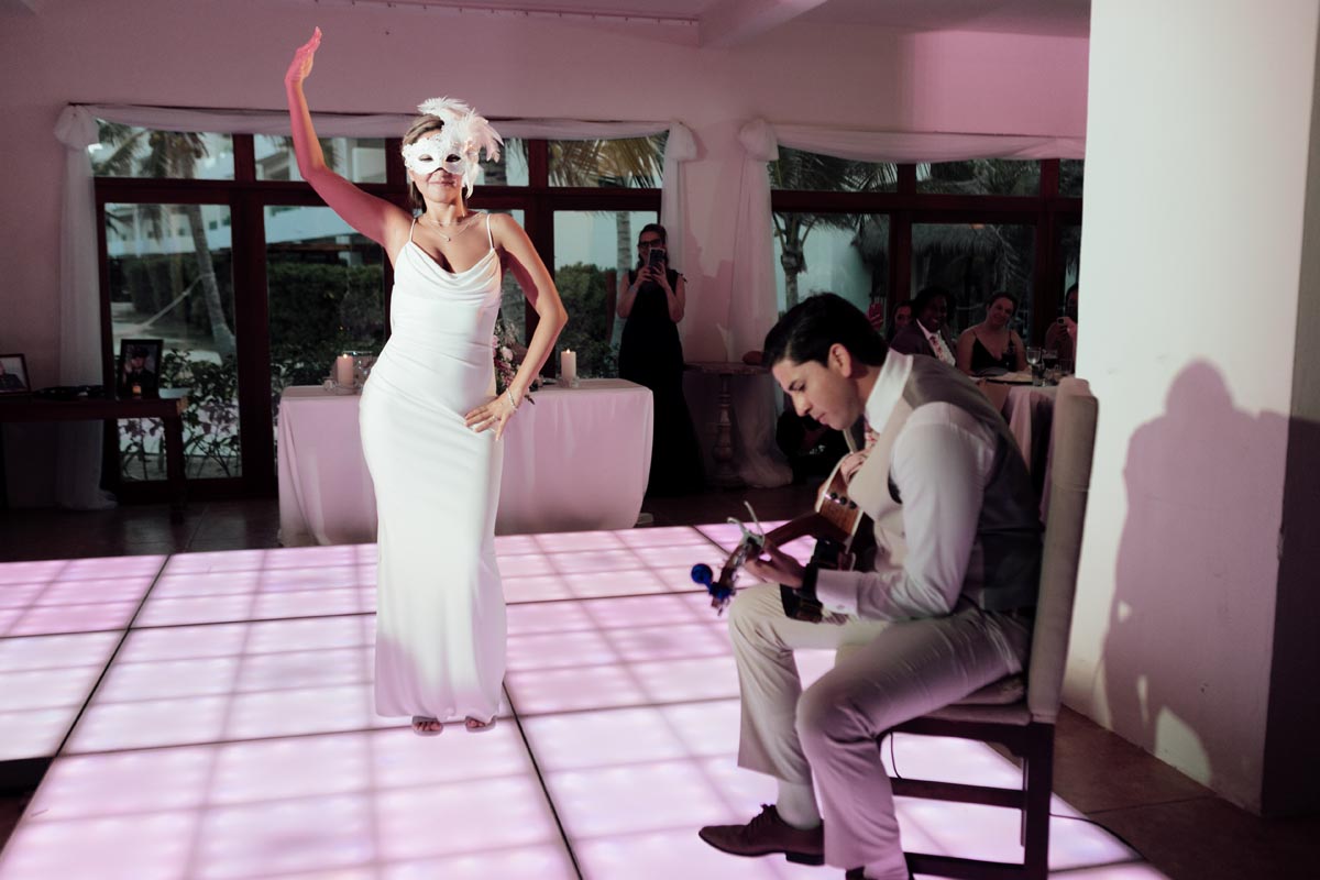 Newlywed husband serenades wife dancing in feathered mask