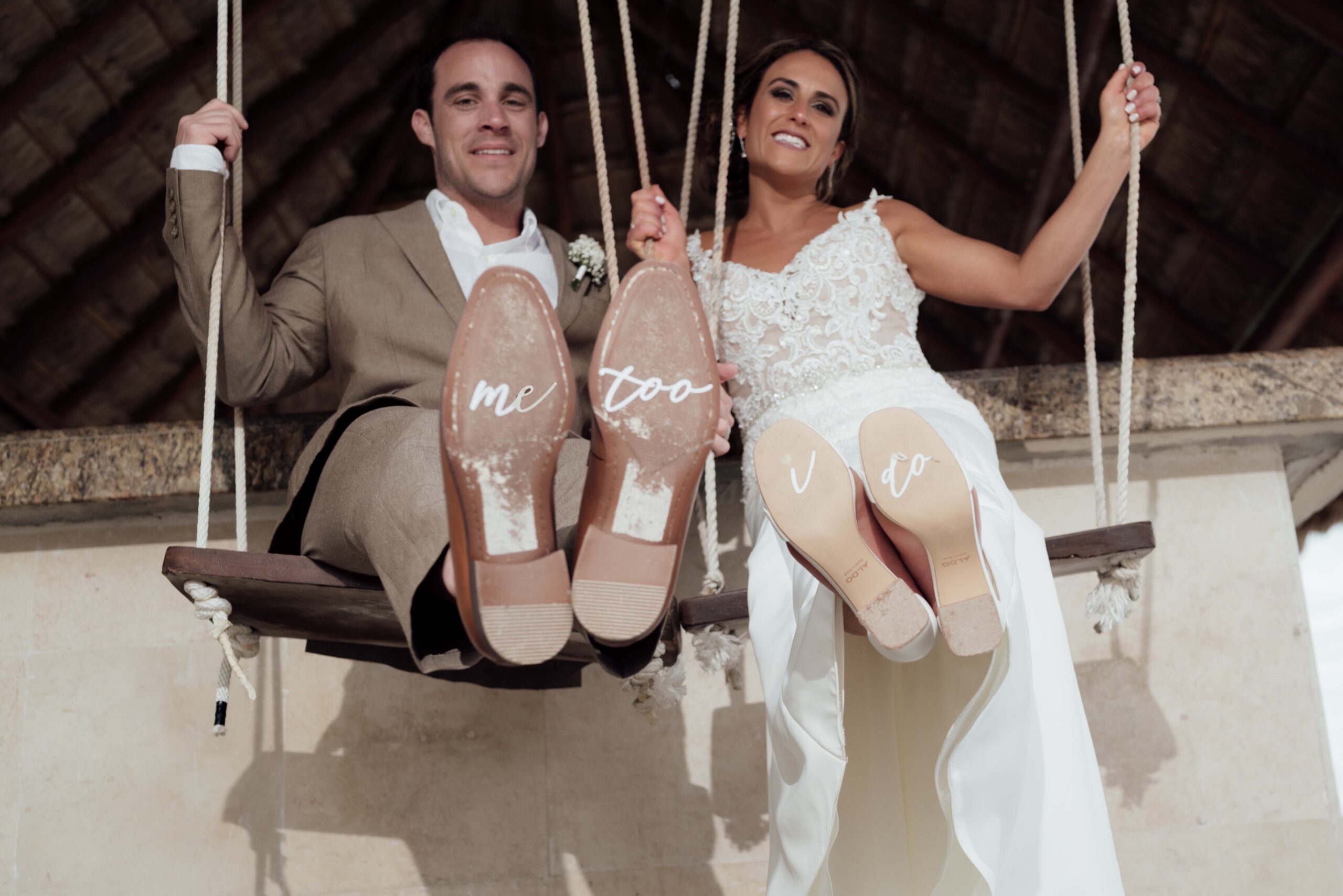 Newlyweds swing on bar swing, showing their shoe soles