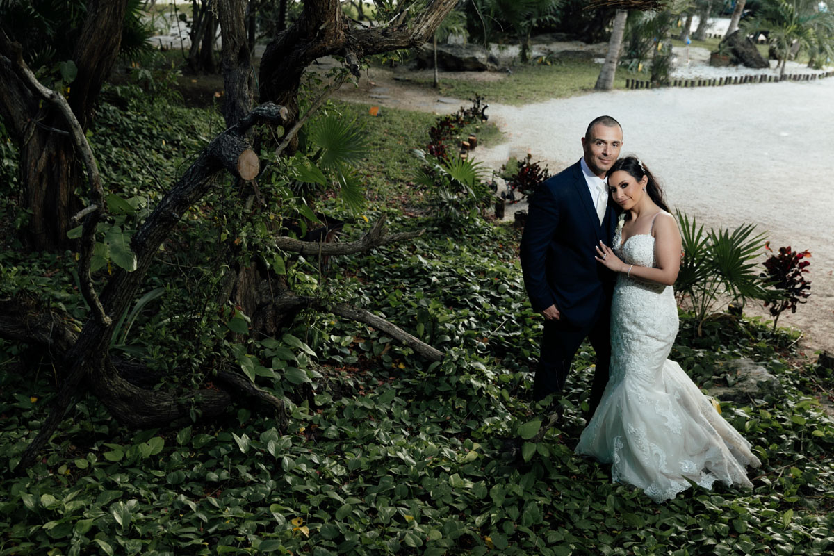 Newlyweds embrace in lush tropical jungle