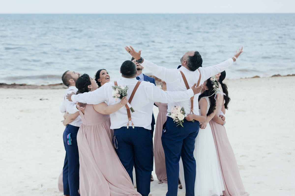 Wedding party cheering on the beach