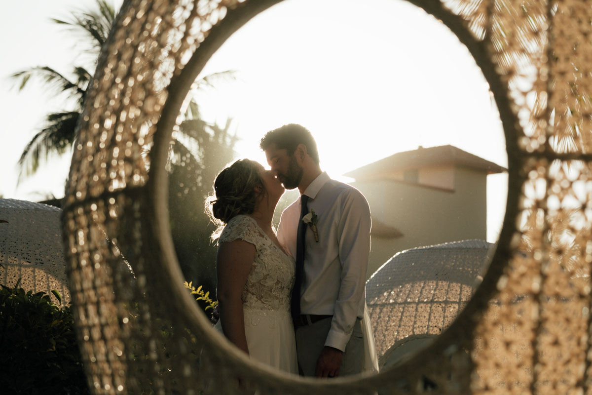 Newlyweds kiss in decorative orb