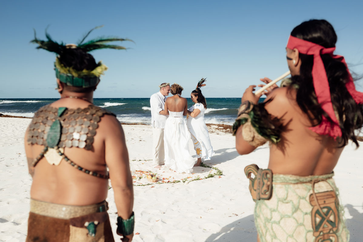 Mayan shaman frame wedding couple on the beach