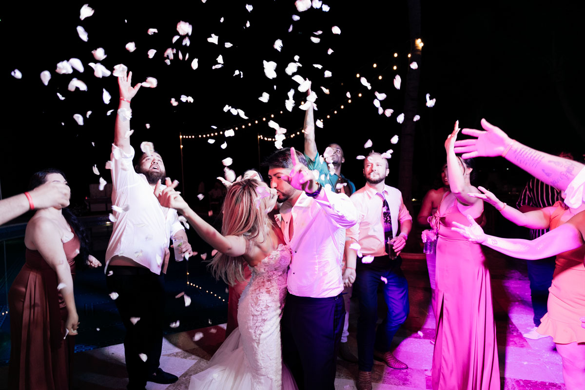 Newlyweds kiss under shower of flower petals