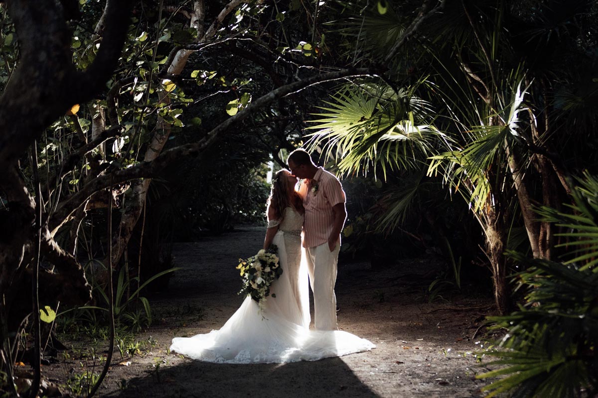 Newlyweds kiss under jungle canopy