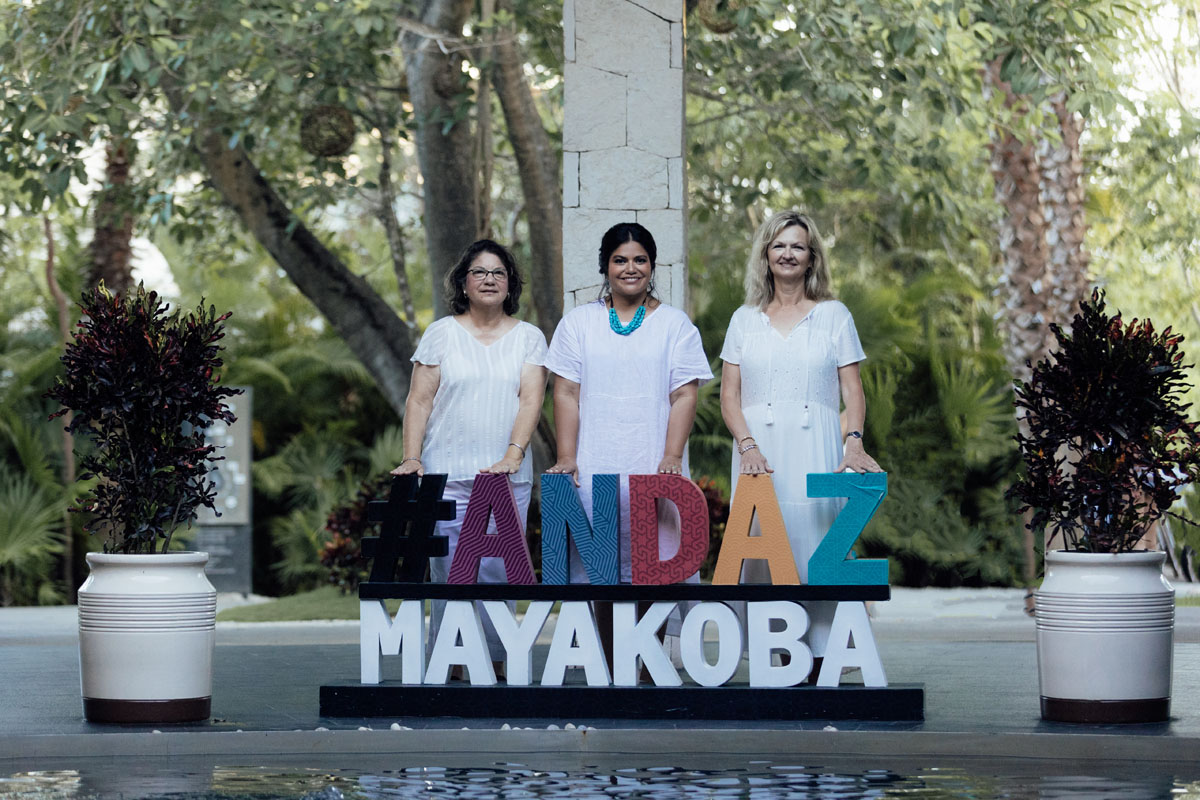 3 friends pose behind Andaz Mayakoba sign