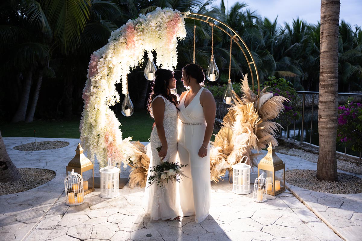 Newlyweds hold each other in front of their circle ceremony arch