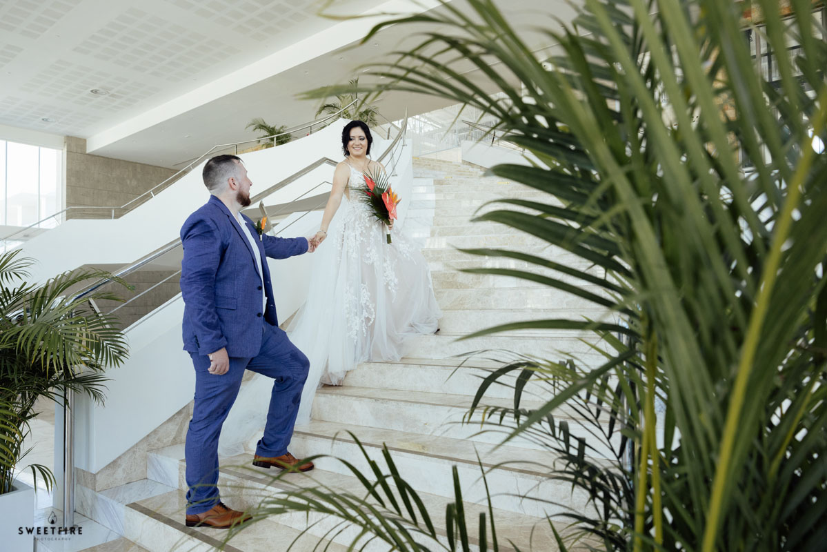 Newlyweds hold hands on steps of Magestic Elegance