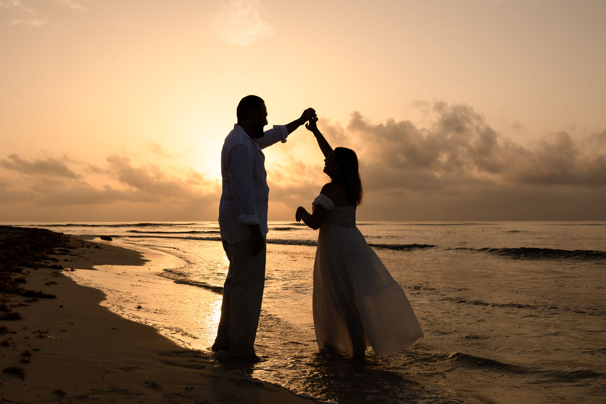 Couple dance on the beach at sunrise