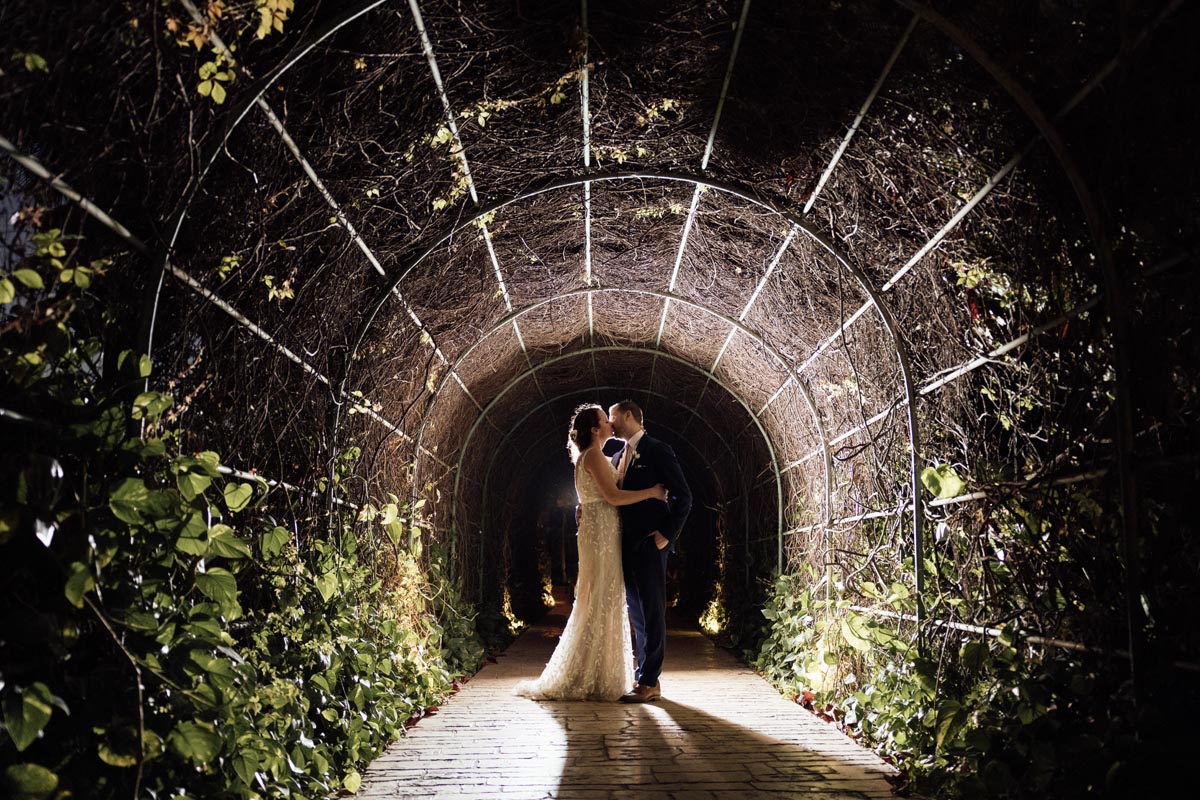 Newlyweds kiss in lighted tunnel