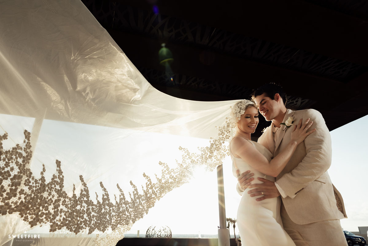 Newlyweds embrace under bride's billowing veil