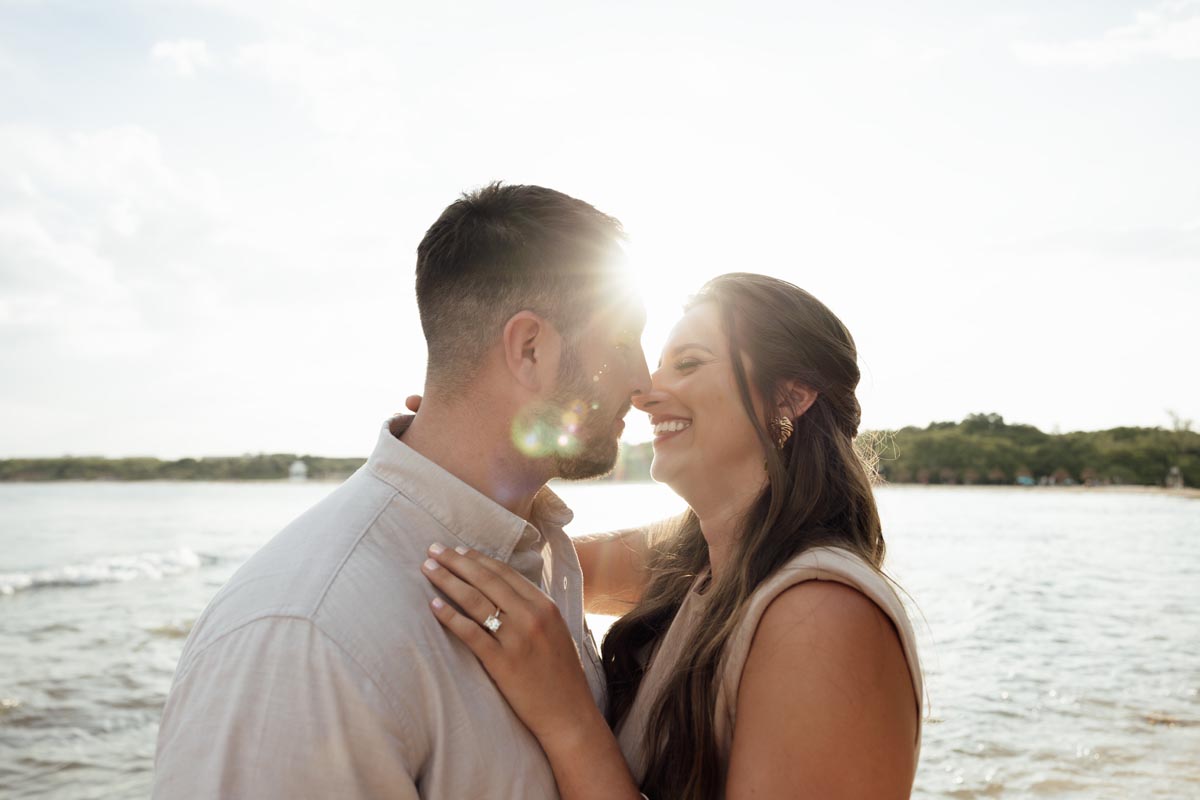 Newlywed couple show of diamond in a sunny embrace