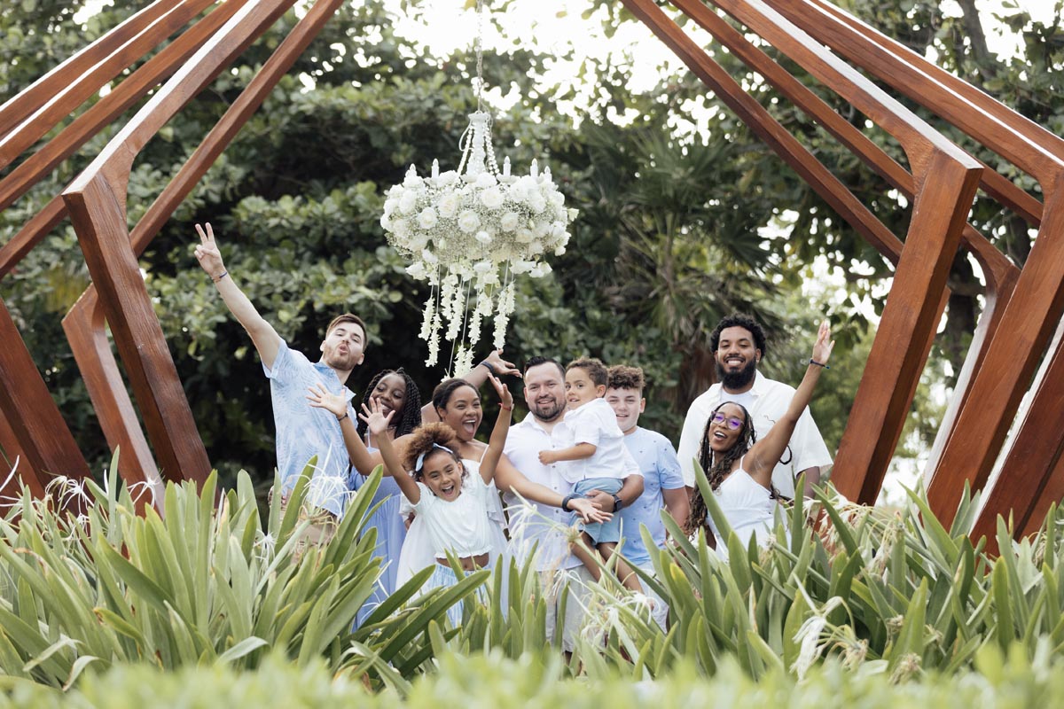 Family cheers on the deck of the Fives pagoda under tropical flowers