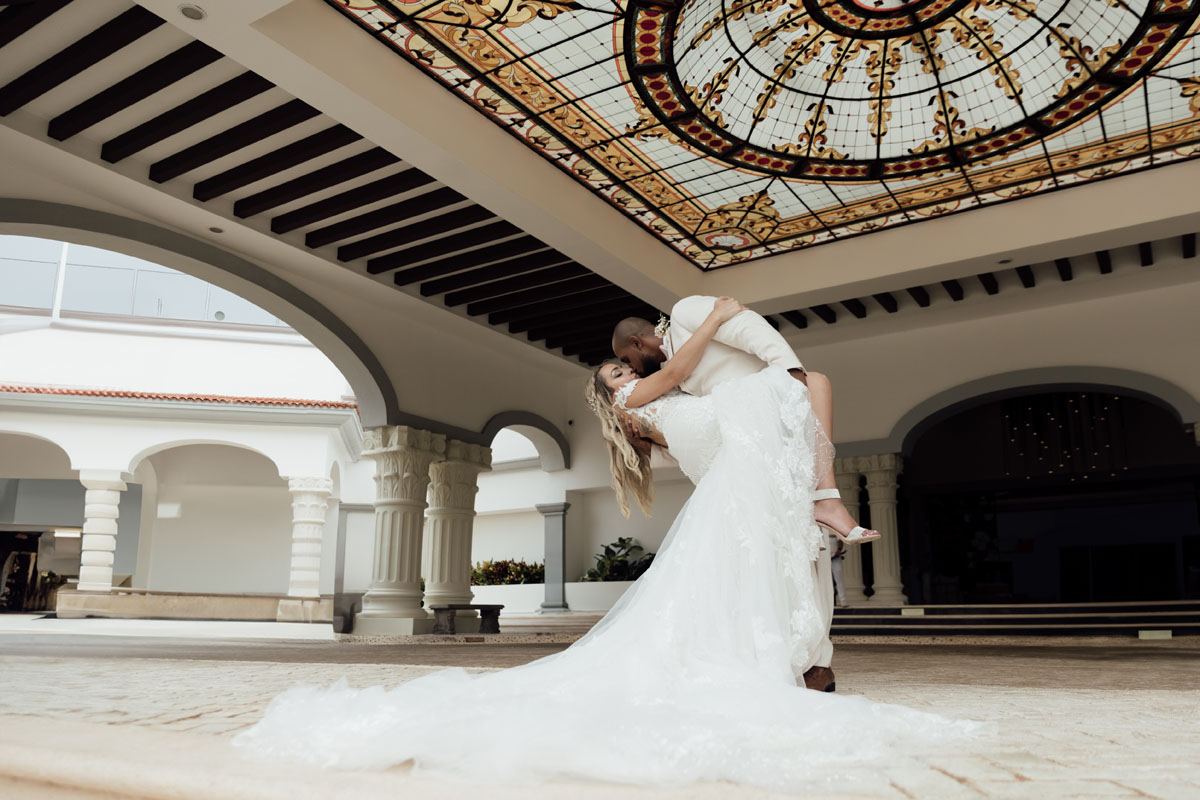 Newlywed groom dips his bride in a passionate kiss under the Hilton dome