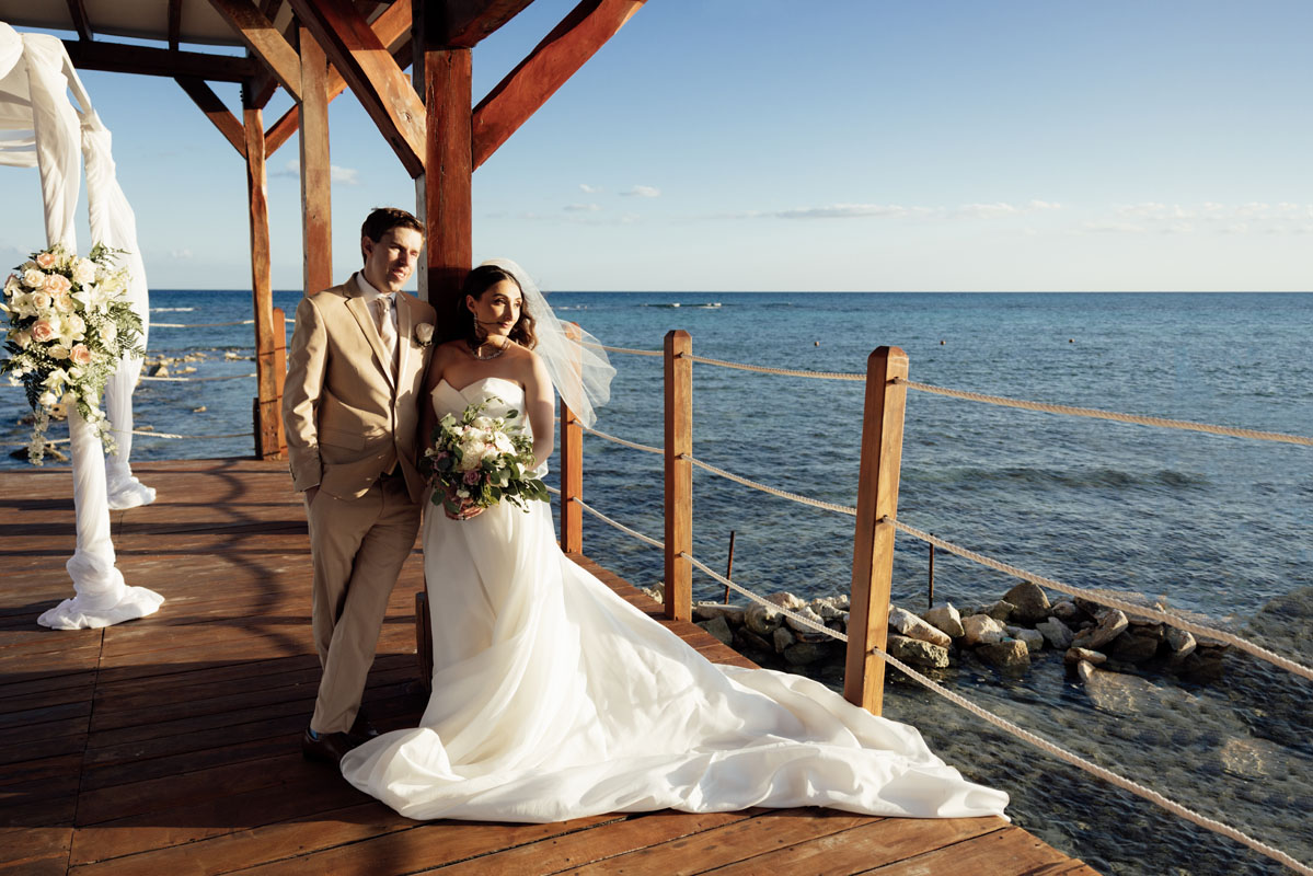Newlyweds embrace looking out to sea