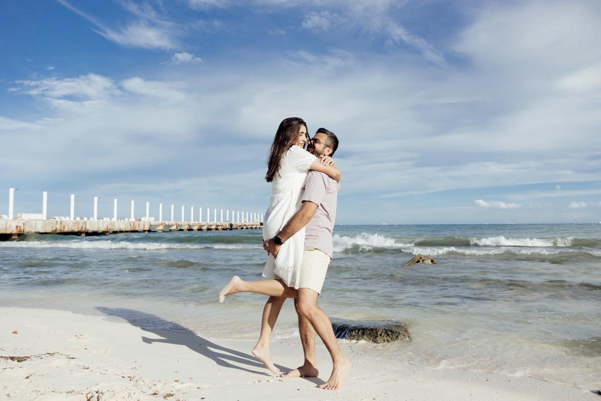Wife jumps into hubby's arms on the beach