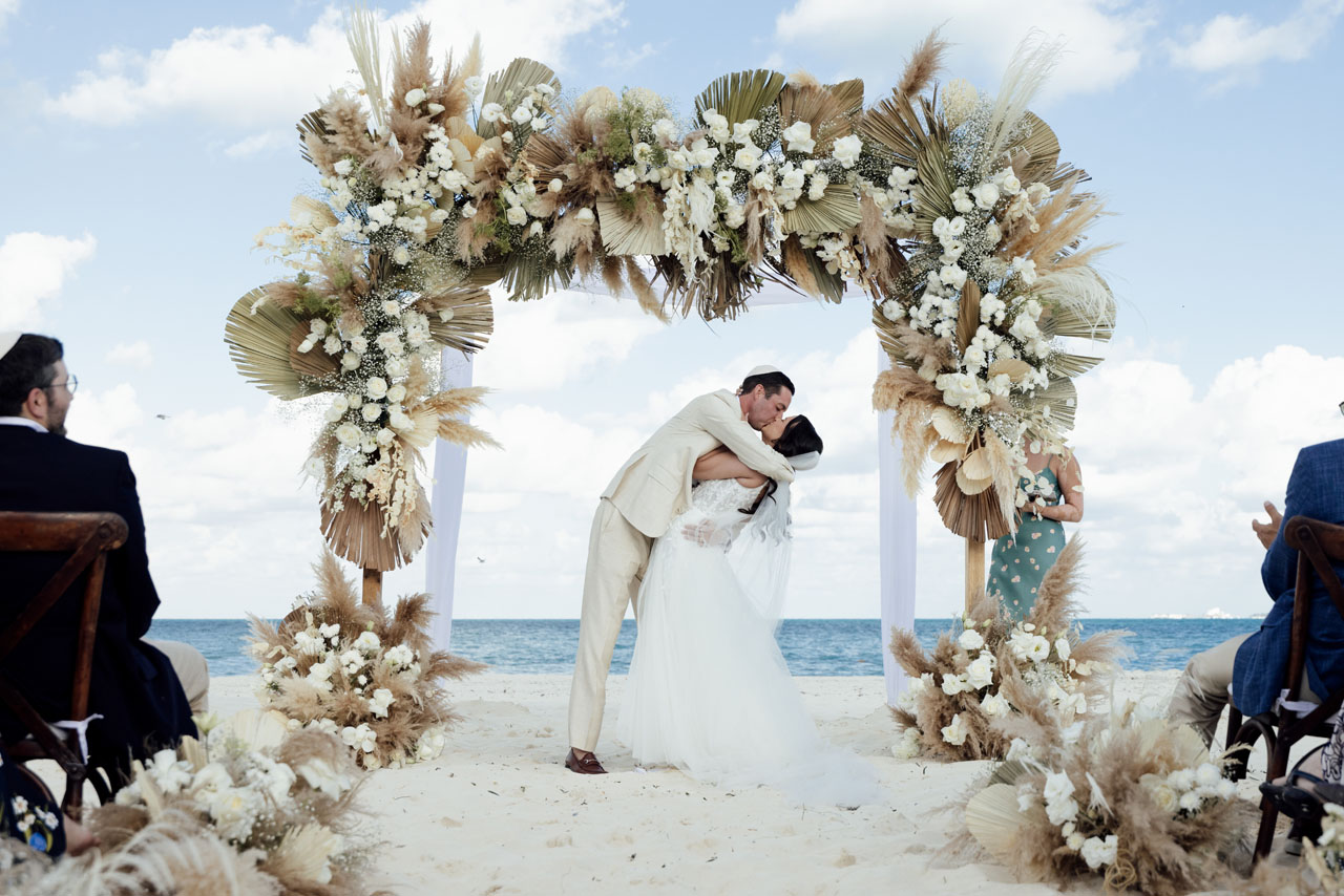 Newlyweds first kiss under elaborate arch