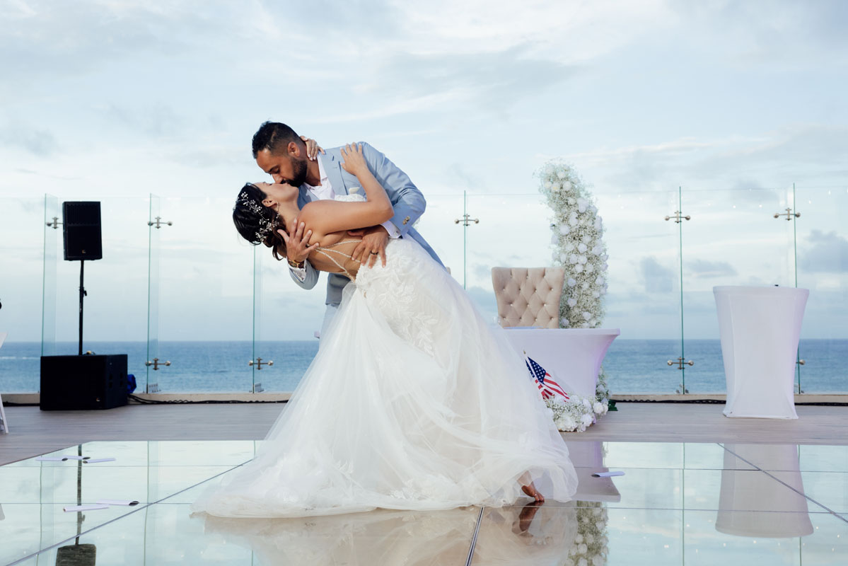 Newlyweds dip in a kiss starting their first dance