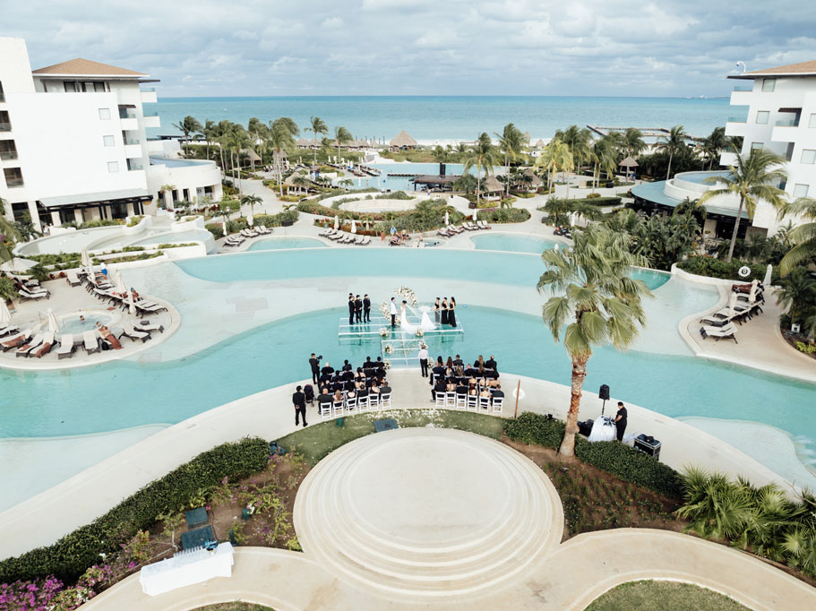 Wedding ceremony on glass deck suspended over an infinity pool with the Caribbean sea in the background