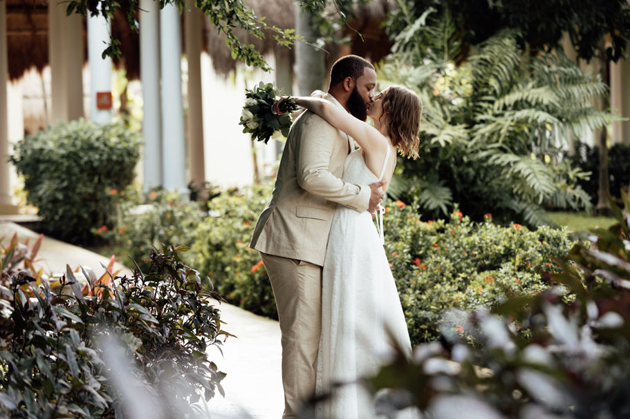 Wedding couple kiss in garden after first look